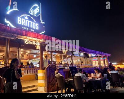 Weitwinkelaufnahme mit der berühmten Hütte Brittos am Strand von baga mit bunten Lichtern und einer Menge von Touristen, die ein Abendessen auf Sandkaraoke und mehr genießen Stockfoto