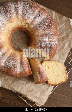 Frisch gebackener Biskuitkuchen auf Holztisch, Blick von oben Stockfoto