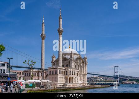 Turkiye. Istanbul. Ein Kreuzfahrtschiff legt vor der Ortakoy-Moschee unter blauem Himmel an Stockfoto