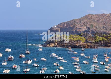 Blick auf die Küste von Cadaques in Katalonien, Spanien, mit zahlreichen Booten auf dem Mittelmeer, weiß getünchten Gebäuden und einer felsigen Küste unter C Stockfoto