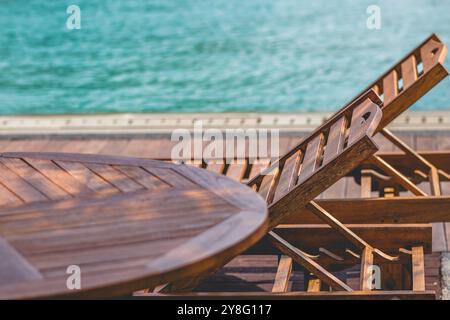 Sonniger Pool-Rückzugsort mit eleganten Sonnenliegen. Idyllische Landschaft Am Pool. Stockfoto