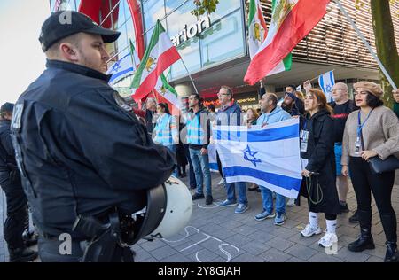 Hamburg, Deutschland. Oktober 2024. Teilnehmer einer pro-israelischen Gegendemonstration zu einer pro-palästinensischen Kundgebung unter dem Motto "Stopp den Völkermord" halten israelische Fahnen auf der Mönckebergstraße. Quelle: Georg Wendt/dpa/Alamy Live News Stockfoto