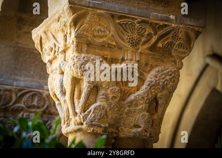 Wölfe in Schafskleidung fressen einen Widder, romanische Hauptstadt im Kreuzgang, Kloster San Pedro el Viejo, Huesca, Gemeinde Aragon, Spanien. Stockfoto