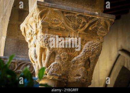 Wölfe in Schafskleidung fressen einen Widder, romanische Hauptstadt im Kreuzgang, Kloster San Pedro el Viejo, Huesca, Gemeinde Aragon, Spanien. Stockfoto