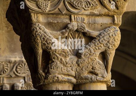 Wölfe in Schafskleidung fressen einen Widder, romanische Hauptstadt im Kreuzgang, Kloster San Pedro el Viejo, Huesca, Gemeinde Aragon, Spanien. Stockfoto