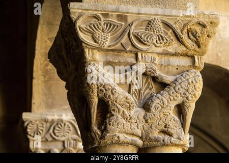 Wölfe in Schafskleidung fressen einen Widder, romanische Hauptstadt im Kreuzgang, Kloster San Pedro el Viejo, Huesca, Gemeinde Aragon, Spanien. Stockfoto