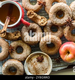 Ein Arrangement von Chia-Obstgarten-Donuts auf einem Kühlregal mit heißem Apfelwein. Stockfoto