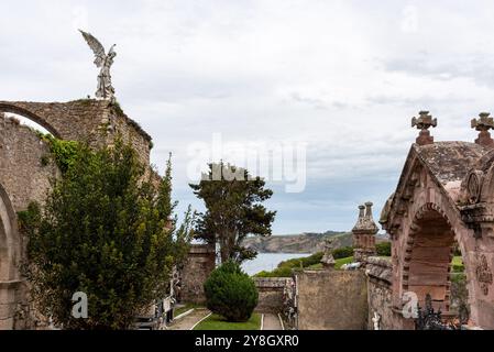 Details zum alten historischen Steinfriedhof in Comillas, einer Engelsstatue mit Blick auf den Ozean, Kantabrien, Spanien Stockfoto