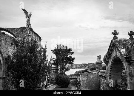 Details zum alten historischen Steinfriedhof in Comillas, einer Engelsstatue mit Blick auf den Ozean, Kantabrien, Spanien Stockfoto