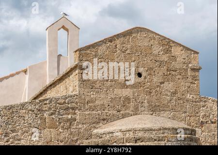 Eine Möwe auf dem Glockenturm der alten Kirche Sant'Efisio in Nora, Sardinien, Italien Stockfoto