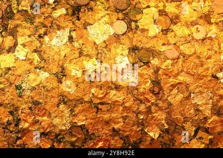 Blattgoldstruktur oder Hintergrund. Blattgold und Münze auf buddha-Statue. Stockfoto