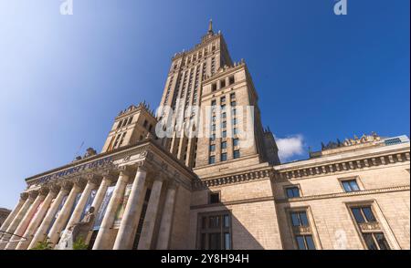 Der Palast der Kultur und Wissenschaft steht hoch vor einem klaren blauen Himmel in Warschau, Polen, und repräsentiert architektonische Schönheit und historische Bedeutung Stockfoto