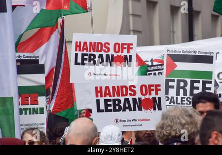 London, Großbritannien. Oktober 2024. Während der Demonstration halten die Demonstranten die Plakate „Hände weg vom Libanon“. Tausende von Menschen marschierten in Zentral-London in Solidarität mit Palästina und dem Libanon, um den ersten Jahrestag des Krieges zwischen Israel und der Hamas zu feiern, der begann, als die Hamas am 7. Oktober 2023 beim Nova-Musikfestival Israelis tötete und entführte. Quelle: SOPA Images Limited/Alamy Live News Stockfoto