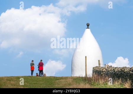 Hundeschlittenfahrer in White Nancy, einem von Menschen geschaffenen Wahrzeichen auf dem Gritstone Trail auf der Spitze des Kerridge Hill mit Blick auf Bollington, Cheshire Stockfoto