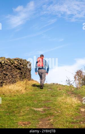 Man wandert mit dem Rucksacktouristen auf dem Langstrecken-Gritstone-Wanderweg auf dem Bergrücken von Kerridge Macclesfield Cheshire England Großbritannien Stockfoto