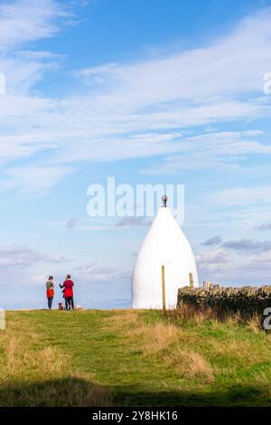 Wanderer und Rucksacktouristen in White Nancy, einem von Menschenhand geschaffenen Wahrzeichen auf dem Gritstone Trail auf der Spitze des Kerridge Hill mit Blick auf Bollington, Cheshire Stockfoto