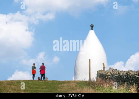 Wanderer und Rucksacktouristen in White Nancy, einem von Menschenhand geschaffenen Wahrzeichen auf dem Gritstone Trail auf der Spitze des Kerridge Hill mit Blick auf Bollington, Cheshire Stockfoto