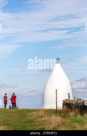 Wanderer und Rucksacktouristen in White Nancy, einem von Menschenhand geschaffenen Wahrzeichen auf dem Gritstone Trail auf der Spitze des Kerridge Hill mit Blick auf Bollington, Cheshire Stockfoto