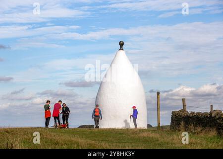 Wanderer und Rucksacktouristen in White Nancy, einem von Menschenhand geschaffenen Wahrzeichen auf dem Gritstone Trail auf der Spitze des Kerridge Hill mit Blick auf Bollington, Cheshire Stockfoto