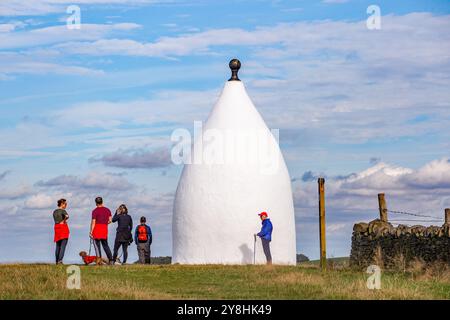 Wanderer und Rucksacktouristen in White Nancy, einem von Menschenhand geschaffenen Wahrzeichen auf dem Gritstone Trail auf der Spitze des Kerridge Hill mit Blick auf Bollington, Cheshire Stockfoto