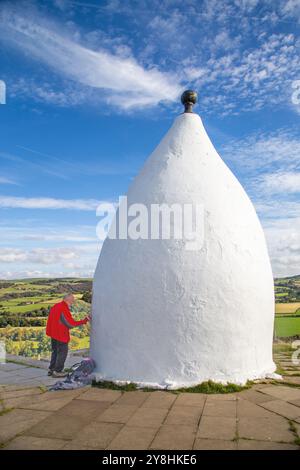 Ein Freiwilliger repariert White Nancy, einen Mann, der auf dem Gritstone Trail auf der Spitze des Kerridge Hill mit Blick auf Bollington, Cheshire, gebaut wurde Stockfoto