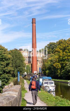 Boote, die auf dem Macclesfield-Kanal bei Bollington nahe Macclesfield Cheshire vor Anker standen, mit Blick auf die ehemalige Baumwollmühle Clarence Mill Stockfoto