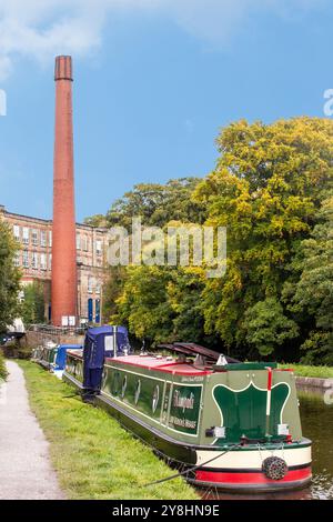 Schmalboote vertäuten am Macclesfield-Kanal bei Bollington bei Macclesfield Cheshire mit Blick auf die ehemalige Baumwollmühle Clarence Mill Stockfoto