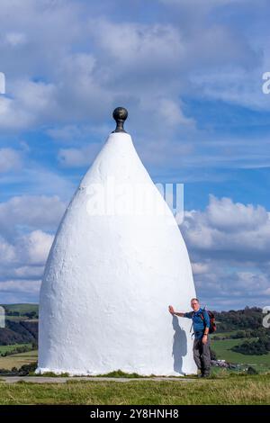 Wanderer und Rucksacktouristen in White Nancy, einem von Menschenhand geschaffenen Wahrzeichen auf dem Gritstone Trail auf der Spitze des Kerridge Hill mit Blick auf Bollington, Cheshire Stockfoto