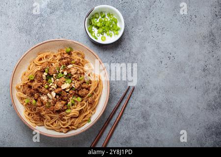 Dan Dan Dan Nudeln serviert mit Essstäbchen und grünen Zwiebeln, traditionelles chinesisches Sichuan-Gericht Stockfoto