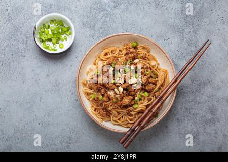 Dan Dan Dan Nudeln serviert mit Essstäbchen und grünen Zwiebeln, traditionelles chinesisches Sichuan-Gericht Stockfoto