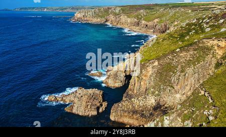 Ein atemberaubender Blick auf die Küste mit zerklüfteten Klippen und klarem blauem Wasser. Die Landschaft bietet eine Mischung aus Felsformationen und üppigem Grün mit Wellen Stockfoto