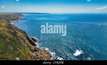 Ein atemberaubender Blick auf die Küste mit zerklüfteten Klippen und einem riesigen blauen Meer unter klarem Himmel. Die Küste bietet felsige Formationen und üppiges Grün Stockfoto