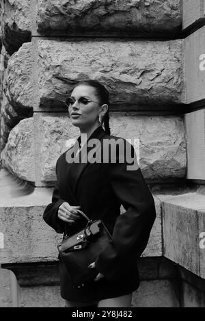 Polina Erofeeva mit komplett schwarzem Outfit kombiniert mit einem übergroßen Blazer, Minirock, Stiefeln und einem birkin auf der Hermès Show in der Pariser Fashion Week SS25 Stockfoto