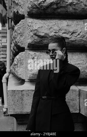 Polina Erofeeva mit komplett schwarzem Outfit kombiniert mit einem übergroßen Blazer, Minirock, Stiefeln und einem birkin auf der Hermès Show in der Pariser Fashion Week SS25 Stockfoto