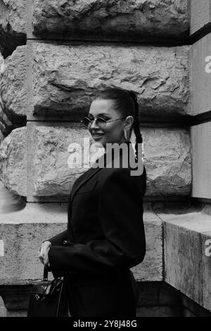 Polina Erofeeva mit komplett schwarzem Outfit kombiniert mit einem übergroßen Blazer, Minirock, Stiefeln und einem birkin auf der Hermès Show in der Pariser Fashion Week SS25 Stockfoto