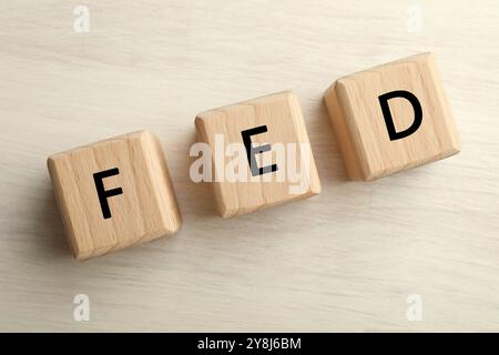 Würfel mit den Buchstaben Fed (Federal Reserve System) auf Holztisch, Draufsicht Stockfoto