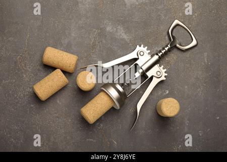 Flügelkorkenzieher und Korken auf grauem Tisch, flach gelegt Stockfoto