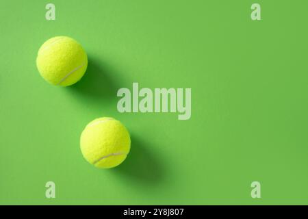 Zwei gelbe Tennisbälle auf grünem Hintergrund. Kopierbereich. Blick von oben. Sommersport. Stockfoto