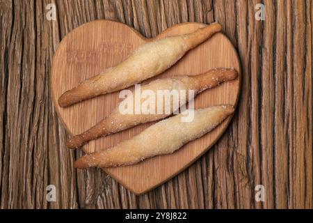 Frisch gebackene Zezette Kekse auf einem hölzernen Herzteller. Stockfoto