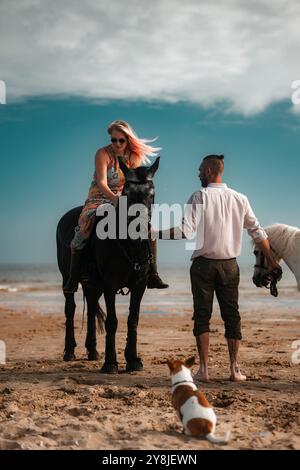 Reitspaar am Strand, Sommerreiter Mann und Frau Stockfoto