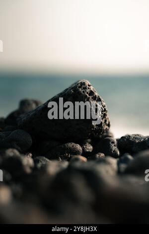 Schwarzes vulkanisches Gestein, poröses Gestein am Strand Stockfoto