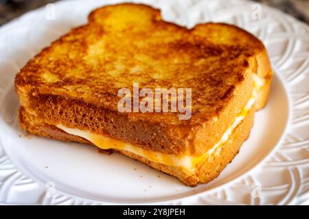 Ein heißer gegrillter Käse auf einem weißen Teller, der zu Hause zubereitet wird, mit einfachem Brot und Cojakkäse. Stockfoto