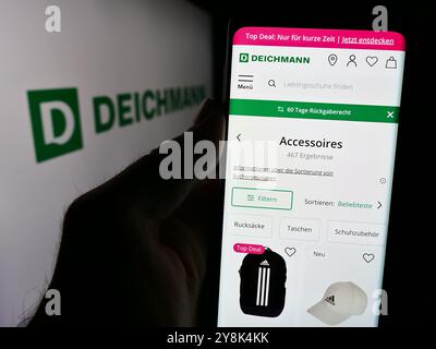 Deutschland. August 2024. In dieser Fotoabbildung hält eine Person ein Smartphone mit der Webseite des deutschen Schuhhandels Deichmann SE vor dem Logo. Quelle: SOPA Images Limited/Alamy Live News Stockfoto