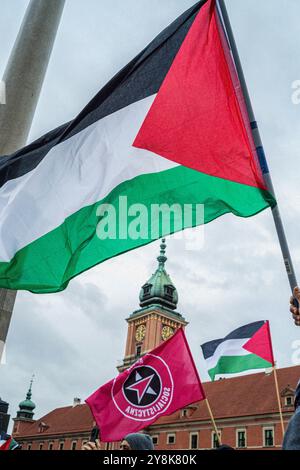 Warschau, Polen. Oktober 2024. Während der Demonstration werden palästinensische Flaggen vor dem polnischen Königsschloss geflogen. Aktivisten, Aktivisten und Demonstranten versammeln sich auf dem Warschauer Schlossplatz, um durch die Straßen der Stadt in Richtung der Botschaft der Vereinigten Staaten von Amerika zu marschieren. Die Demonstranten marschieren aus Protest gegen den anhaltenden Völkermord Israels in Palästina und die sich entwickelnden Angriffe auf den Libanon, während der Jahrestag des 7. Oktober naht. Quelle: SOPA Images Limited/Alamy Live News Stockfoto