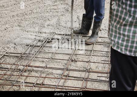 Bauarbeiter gießen eine verstärkte Platte im Erdgeschoss. Stockfoto