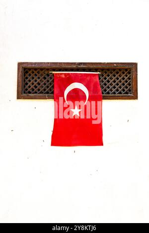 Türkische Flagge hängt an einer weißen Wand in Mudanya, Turkiye. Stockfoto