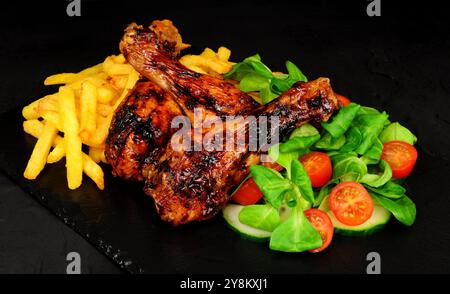 Gegrillte Hähnchenflügel mit Pommes frites, Lammsalat und Zitronengarnitur Stockfoto