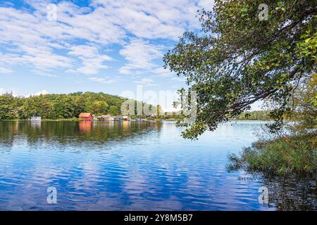 Bootshäuser und Bäume am Krakauer See in der Stadt Krakau am See, Deutschland. Stockfoto