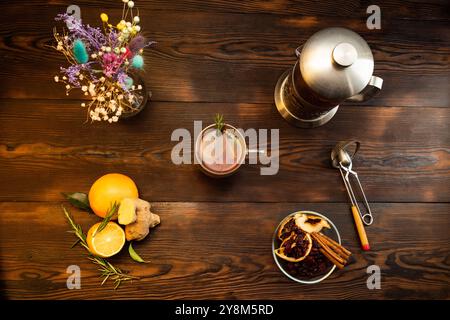 Tee-Stillleben. Tee und Gewürze auf dem Tisch. Tee mit Zitrone und Gewürzen. Sträuße und eine Teekanne auf dem Tisch. Flache Lagen. Stockfoto
