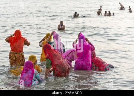 Hinduistische Pilger, Frau in farbenfrohen Saris, nehmen ein heiliges Bad im Meer vor Sonnenaufgang in Ghat Agni Theertham, Rameswaram oder Rameshwaram, Pamban Island Stockfoto